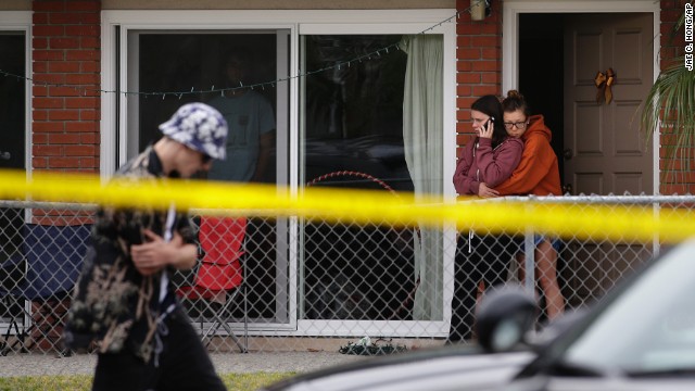 Two women comfort each other Saturday near the scene of a shooting. Seven people also were being treated in a hospital for gunshot wounds or traumatic injuries, a sheriff's office spokeswoman said.