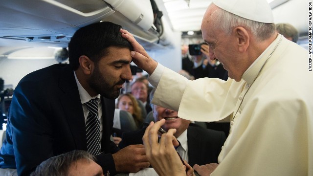 Pope Francis blesses a man as he greets journalists aboard the papal flight on his way to Jordan on May 24. 