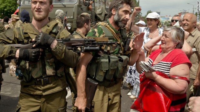 A woman holds the hand of a pro-Russian gunman in Donetsk's Lenin Square on May 25. A large separatist rally was held in Donetsk around lunchtime. The protesters chanted pro-Russian slogans as they were addressed by separatist leaders.