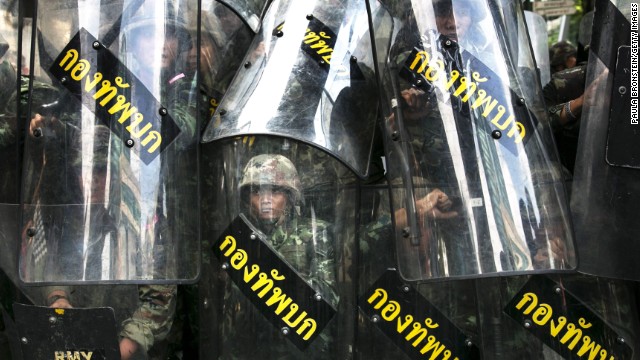 Thai soldiers stand behind their riot shields as protesters threaten them May 25 in Bangkok. 