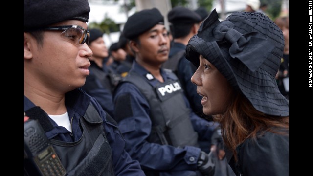 An anti-coup protester faces riot police during a May 26 rally in Bangkok.