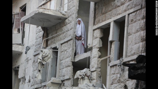 A woman stands in a heavily damaged building in Aleppo on May 26.