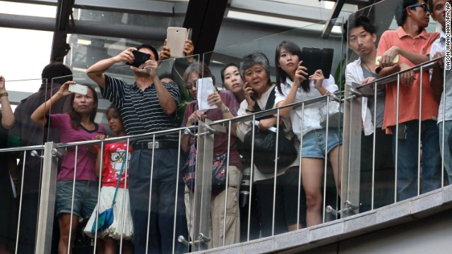 Onlookers at a Bangkok shopping mall watch as protesters shout "Freedom!" and "Democracy!" on June 1.