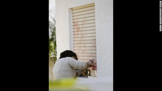 In this photo from 2007, a Portuguese police officer searches for evidence on the window that leads to the room where Madeleine was sleeping. 