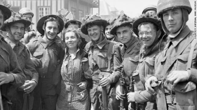 British troops pose for a photograph with a French woman in La Breche d'Hermanville.