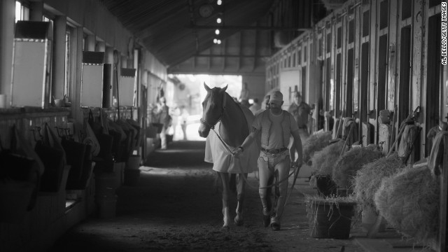 California Chrome, seen here with exercise rider Willie Delgado in his barn after training at Belmont, has been dubbed a horse racing "rock star."