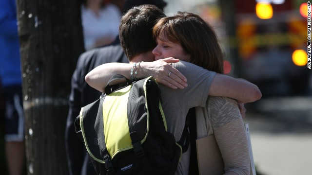 Bystanders embrace near the scene. 