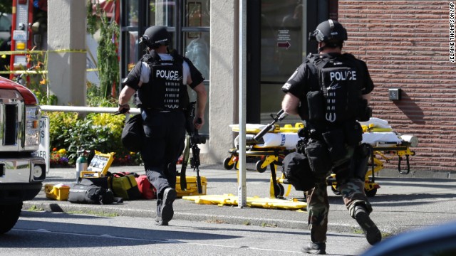 Seattle police officers run toward a campus building after the shooting June 5.