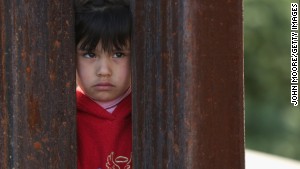 A child on the Mexican side of the U.S.-Mexico border fence looks into Arizona during a special \'Mass on the Border\' on April 1, 2014 in Nogales, Arizona.