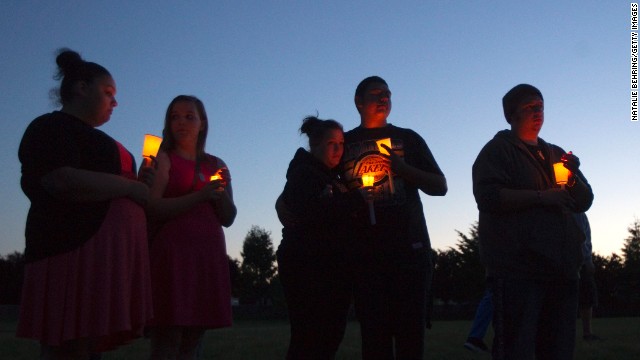 Friends, family and others hold candles for the victim of a school shooting at a vigil Tuesday, June 10 in Troutdale, Oregon, near Portland. A student shot and killed another student at Reynolds High School before apparently taking his own life, law enforcement sources said.