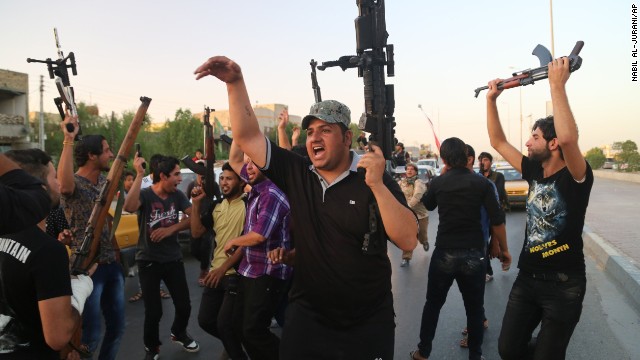 Shiite tribal fighters raise their weapons and chant slogans against ISIS in Basra, Iraq, on June 15. 