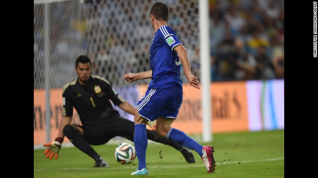 Substitute Vedad Ibisevic shoots past Argentina goalkeeper Sergio Romero to score Bosnia-Herzegovina's historic first World Cup goal Sunday, June 15, at the Maracana Stadium in Rio de Janeiro. But Argentina won the match 2-1.