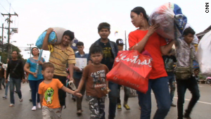 Cambodian workers gathered their belongings and their children to make the journey back to their home country. 