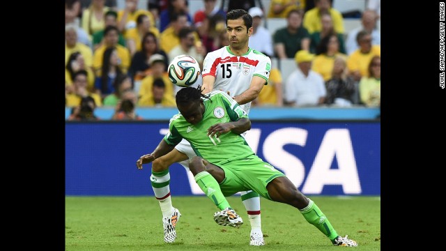 Iranian defender Pejman Montazeri (No. 15) challenges Nigeria's Victor Moses.