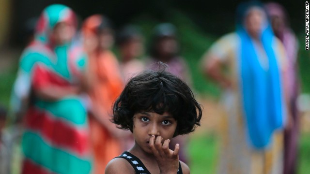 A girl looks at a burned house in Aluthgama.