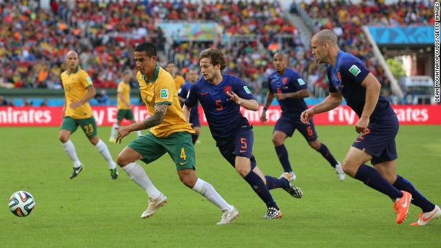 Australia's Tim Cahill dribbles past Dutch players. Cahill had a tremendous volley in the first half to tie the game at 1-1.