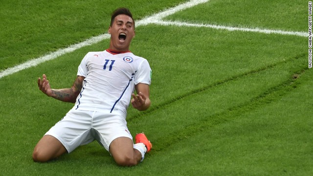 Chile forward Eduardo Vargas slides on the grass after scoring the game's opening goal.