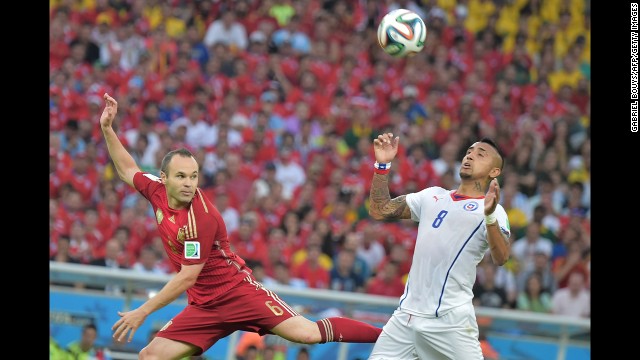 Iniesta and Chilean midfielder Arturo Vidal compete during the match.