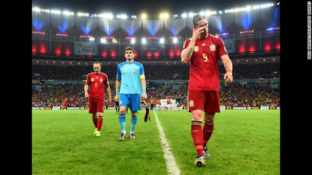 From left, Spanish players Andres Iniesta, Iker Casillas and Fernando Torres walk off the field after losing 2-0 to Chile. Four years after winning the World Cup, Spain is now the first team to be eliminated from the soccer tournament.