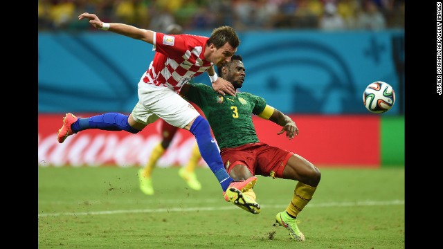 Croatia's Mario Mandzukic heads the ball past Cameroon's Nicolas Nkoulou.