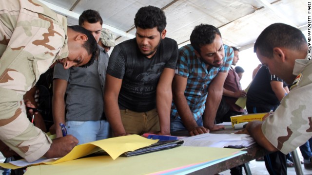 Iraqi men register to fight alongside security forces Friday, June 20, at a recruitment center in Baghdad.