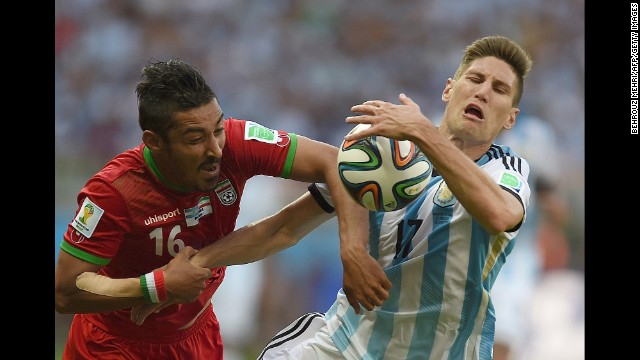 Iran forward Reza Ghoochannejhad, left and Argentina defender Federico Fernandez vie for the ball. 