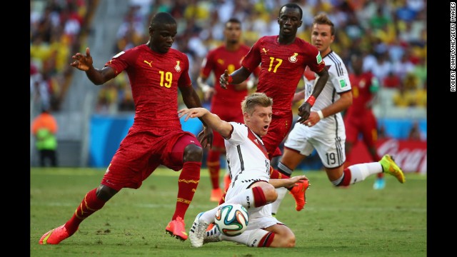 Toni Kroos of Germany is challenged by Jonathan Mensah, left, and Mohammed Rabiu of Ghana. 