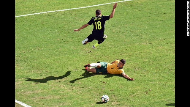 Spain defender Jordi Alba, top, vies with Australia forward Mathew Leckie.