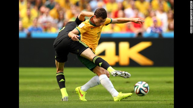 Australia's Oar is challenged by Spain's Juanfran.