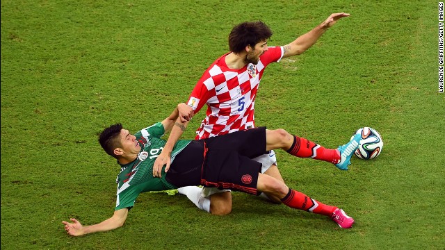 Oribe Peralta, left, of Mexico tackles Vedran Corluka of Croatia.