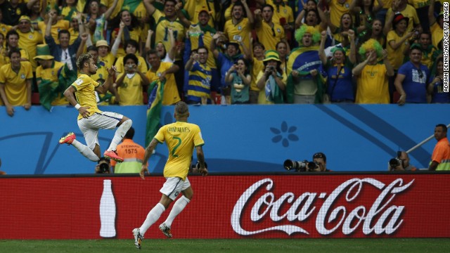 Brazil forward Neymar, left, celebrates with his teammate Dani Alves after scoring Brazil's second goal against Cameroon.