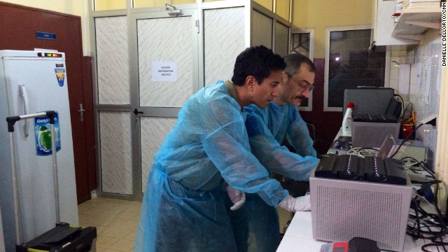 CNN's Dr. Sanjay Gupta, left, works in the World Health Organization's mobile lab in Conakry. Gupta traveled to Guinea in April to report on the deadly virus.