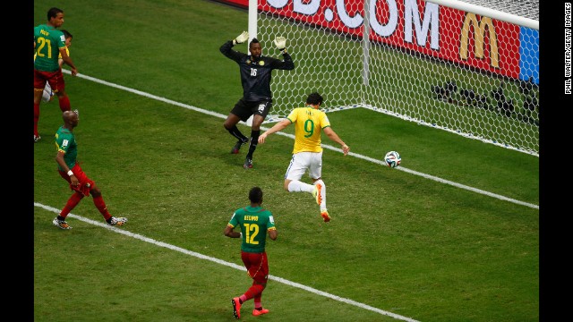 Fred of Brazil scores his team's third goal on a header past Charles Itandje of Cameroon.