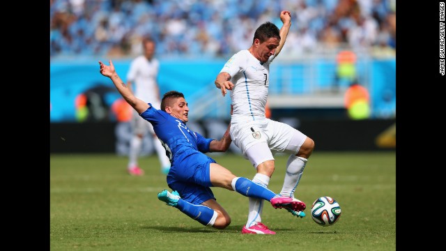 Marco Verratti of Italy tackles Cristian Rodriguez of Uruguay. 