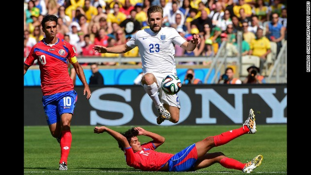England defender Luke Shaw jumps over a Costa Rica player while going after the ball. 