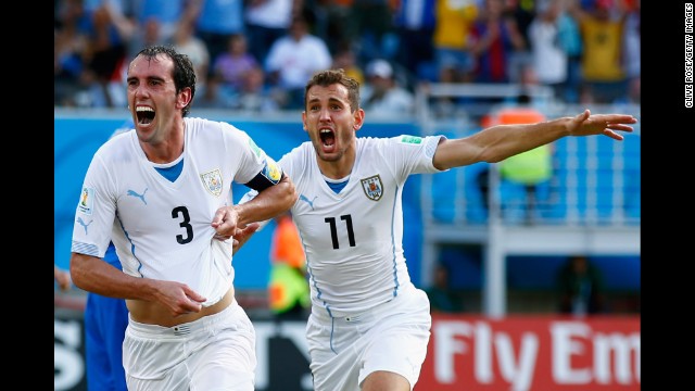 Diego Godin of Uruguay, left, celebrates scoring his team's first goal during a match against Italy in Natal, Brazil. Uruguay won 1-0.