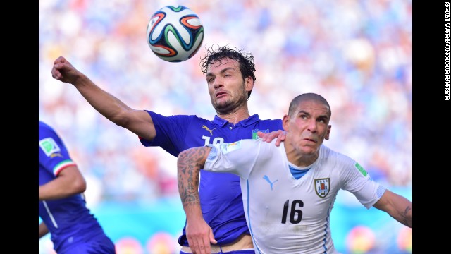 Italy's Marco Parolo, left, and Uruguay's Maximiliano Pereira vie for the ball. 