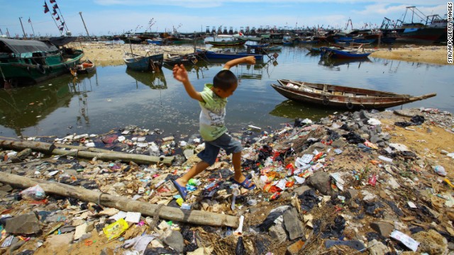 A Chinese boy runs along the trash-strewn beach along the sea coast in Anquan village, which is in Hainan province, in 2011.