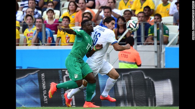 Ivory Coast's Serge Aurier, left, challenges Greece's Lazaros Christodoulopoulos.