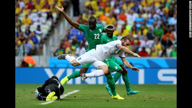 Boubacar Barry of the Ivory Coast makes a save while Dimitris Salpingidis of Greece tries to take a shot.
