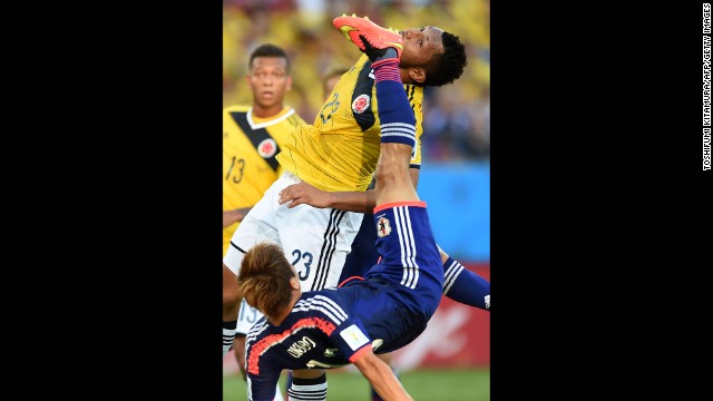 Japan's Yoshito Okubo, bottom, and Colombia's Carlos Valdes vie for the ball.