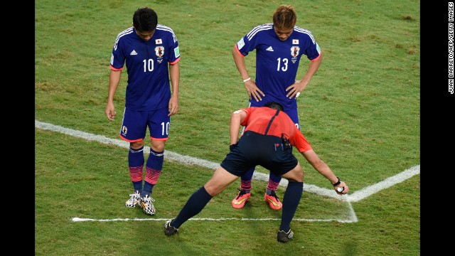 Referee Pedro Proenca sprays a free kick line during the match between Japan and Colombia.