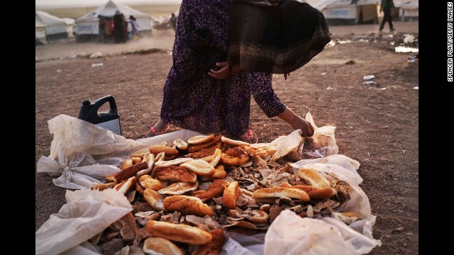 A woman gathers bread in a temporary displacement camp for Iraqis caught up in the fighting in and around Mosul on Tuesday, June 24. 