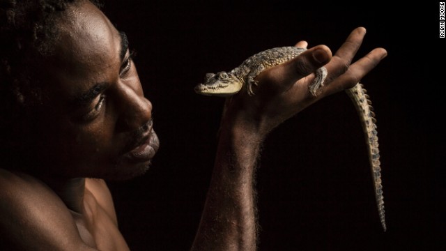Kenroy "Booms" Williams holds an American crocodile. Booms monitors the vulnerable crocodiles and the critically endangered Jamaican iguanas in the Portland Bight Protected Area of Jamaica. 