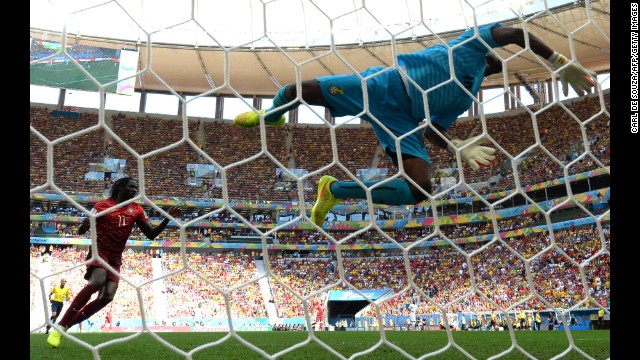 Ghana goalkeeper Fatau Dauda dives for the ball.