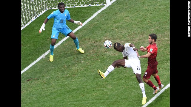 Ghana defender John Boye, center, hits the ball to score an own-goal as Portugal midfielder Joao Moutinho, right, watches on and Ghana goalkeeper Fatau Dauda tries to defend on June 26.