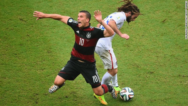 Lukas Podolski of Germany is challenged by Kyle Beckerman of the United States.