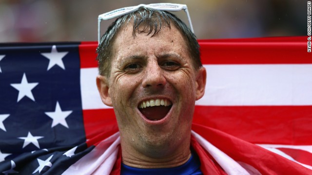 A fan looks on in the rain during the World Cup match between the United States and Germany in Recife, Brazil.