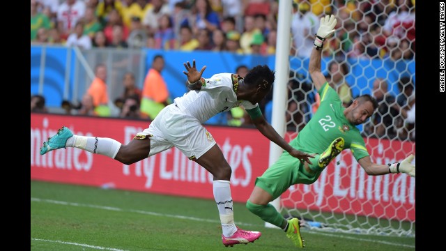 Ghana forward and captain Asamoah Gyan, left, scores past Portugal's goalkeeper Beto during the match between Portugal and Ghana.