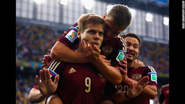 Kokorin celebrates scoring his team's first goal with teammate Oleg Shatov on his back in a match against Algeria. 